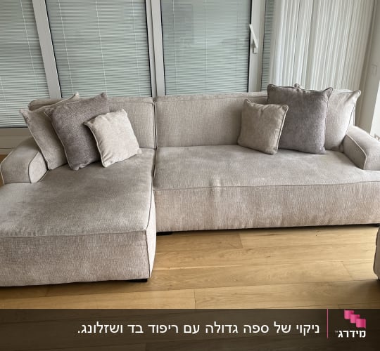 ספה אפורה עם כריות על רצפת עץ